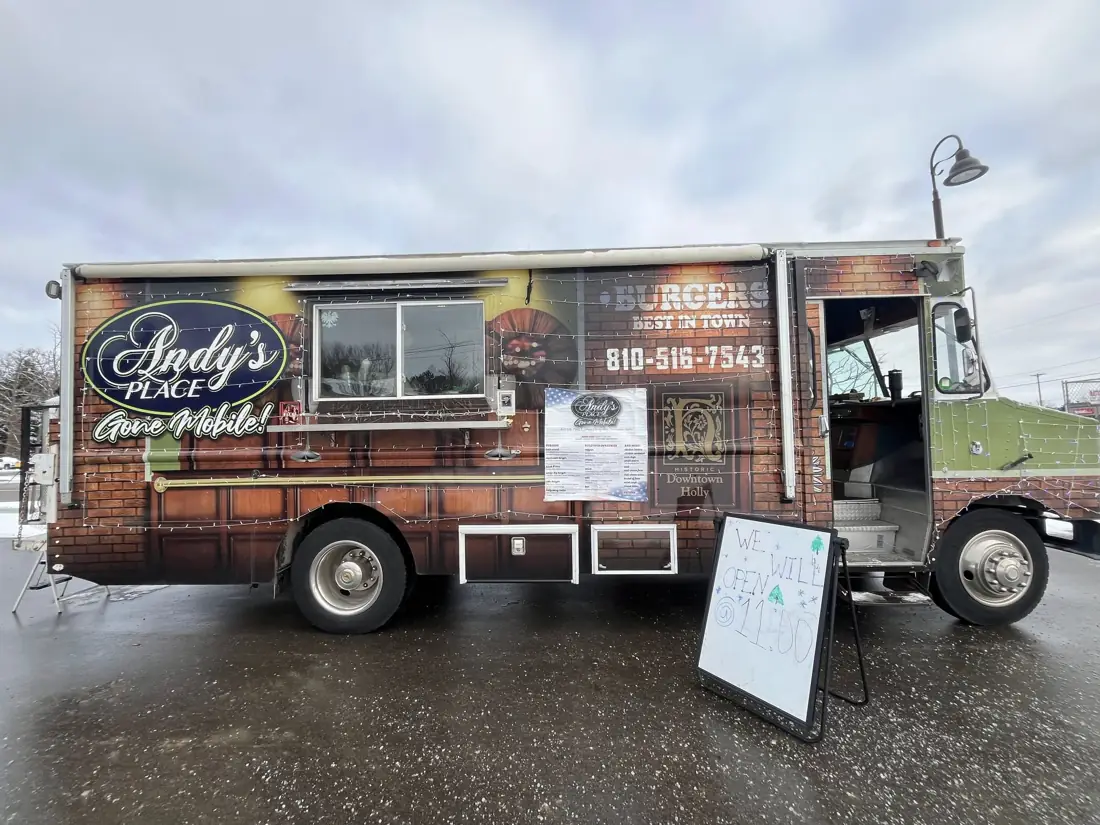 The Andy's Place Gone Mobile food truck, wrapped in red brick with the Andy's logo and 810-516-7543 on the side